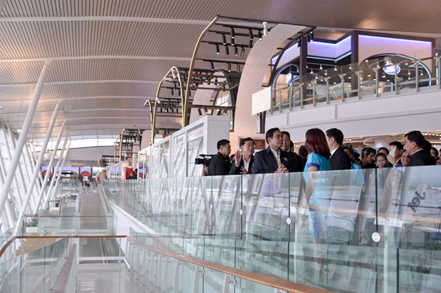 Prime Minister Prayut Chan-o-cha is shown around the new passenger terminal at Phuket airport on Friday. (Government House photo)