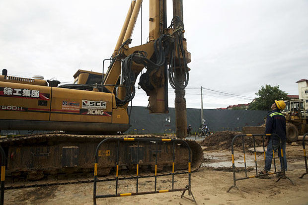 A worker watches machinery operating at a construction site in Phnom Penh on Sept 13, 2016. Cambodia saw almost zero inflow of foreign direct investment from Vietnam in the first six months of this year. (Bloomberg photo)