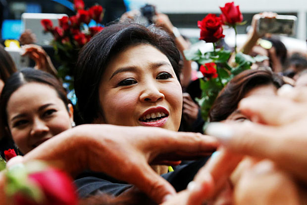 Former prime minister Yingluck Shinawatra greets supporters as she arrived at the Supreme Court on Aug 5, 2016 for a trial on the rice subsidy scheme during her administration. (Reuters photo)