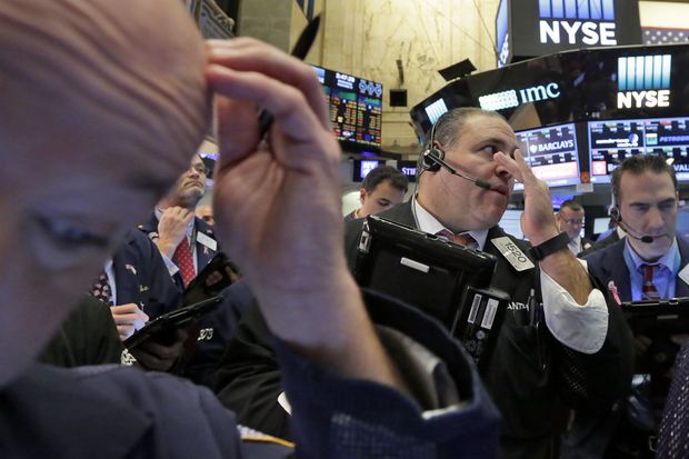 In this Nov 9, 2016 file photo, Anthony Riccio (centre) works with fellow traders on the floor of the New York Stock Exchange. (AP photo)