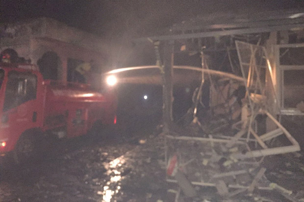 A fireman hoses down the burned out cooperative store in Moo 3 village of tambon Piya Mumang in Pattani's Yaring district after the car bomb explosion on Thursday evening that injured 5 people. (Photo by Abdulloh Benjakat)