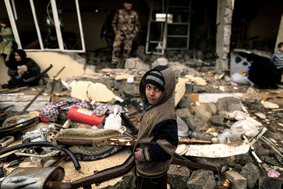 A displaced Iraqi boy who just fled his home waits to be transported, as Iraqi forces battle with Islamic State militants, in western Mosul. — Reuters