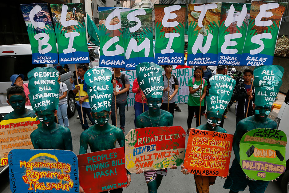 Protesters, mostly indigenous peoples and environmentalists, picket a mining company in Makati city east of Manila to demand its closure. — AP