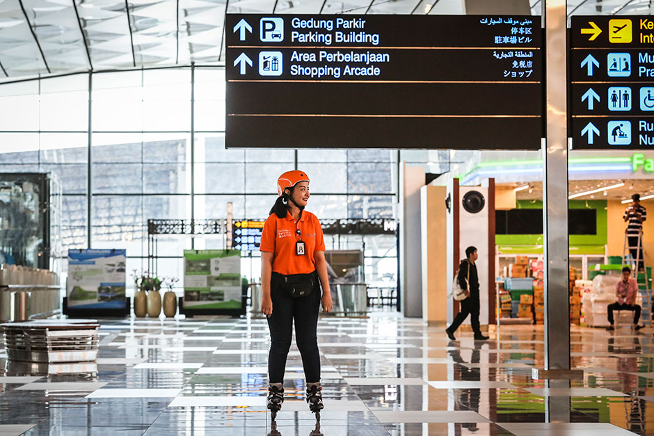 An Indonesian airport customer service official uses inline skates at
