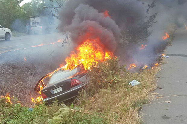 A car goes up in flames after falling into a ditch and hitting a tree in Phanom Sarakham district on Tuesday. Four people were killed. (Photo by Sontanaporn Inchan)