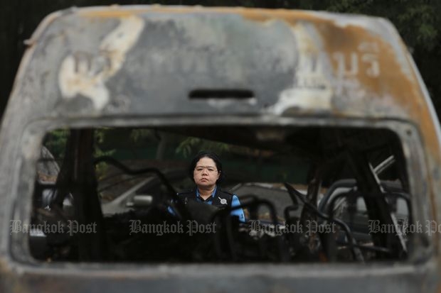 A Chon Buri forensic official on Thursday inspects the charred wreckage of the van involved in a crash which killed 25 in the eastern province on Monday. (Photo by Patipat Janthong)