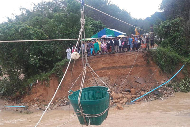 This pulley line with a basket to carry people and supplies was erected across a   flooded canal after the bridge was washed away in Nop Phi Tam district of Nakhon Si Thammarat on Thursday afternoon. (Photo by Nujaree Raekrun)