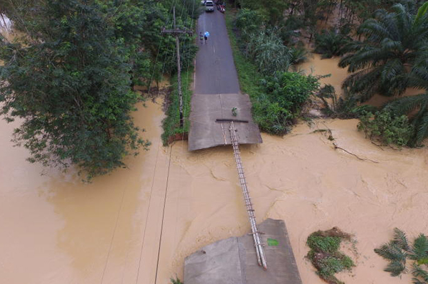 By Monday this makeshift walkway had been built across part of the Bang Pan-Khuan Sinchai road that was washed away by the flooding in tambon Sai Thong of Surat Thani's Chai Buri district. (Photo by Supapong Chaolan)