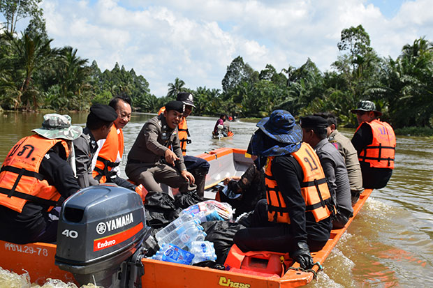 Officials use boats to distribute relief bags and clean water to help flood victims in Cha-out district in Nakhon Si Thammarat on Sunday. (Photo by Nujaree Raekrun)