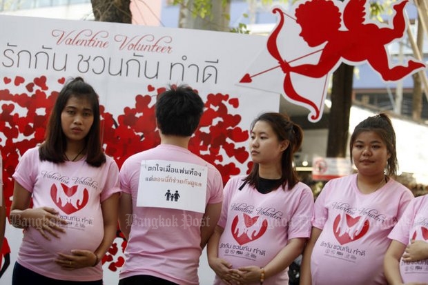 Young women pretending to be pregnant remind bystanders of the dangers of Valentine's Day sex. (Photo by Thanarak Khunton)