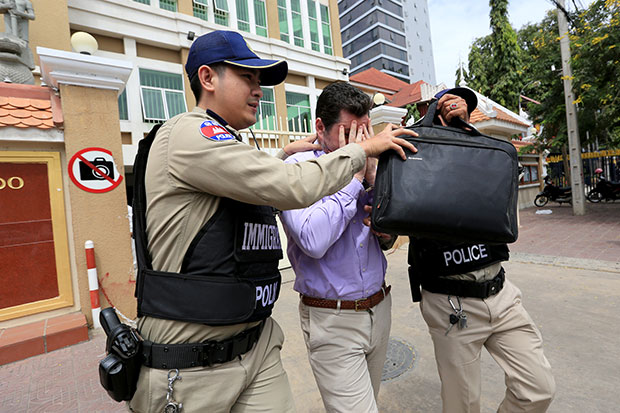 Toby James Nelham hides his face from the cameras after Cambodian immigration police arrested him in Phnom Penh on Wednesday. (Khmer Times photo) Toby James Nelham hides his face from the cameras after Cambodian immigration police arrested him in Phnom Penh on Wednesday. (Khmer Times photo)