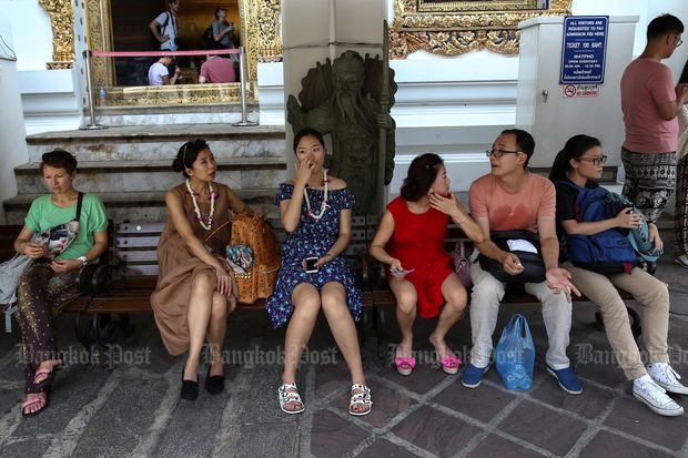 Chinese tourists take a break at Wat Pho in Bangkok on Oct 3, 2016. (Reuters photo)