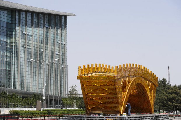 A worker puts the finishing touch on a 'Golden Bridge of Silk Road' structure outside the National Convention Centre in Beijing, where the New Silk Road summit is to be held on May 14-15. (AP photo)