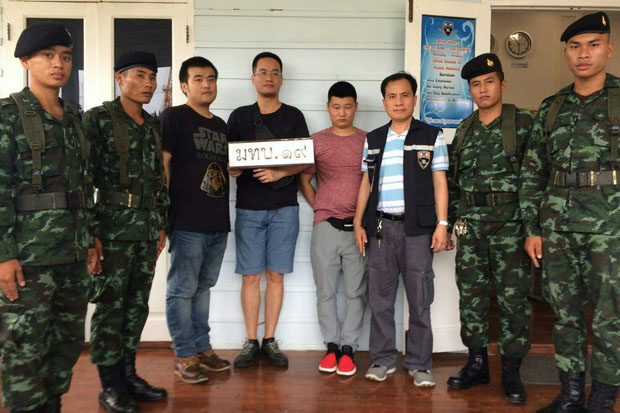 Three Chinese suspects (third to fifth from the left) are brought to the 19th Military Circle in Aranyaprathet district, Sa Kaeo, on Monday. (Photo by Sawat Katengam)