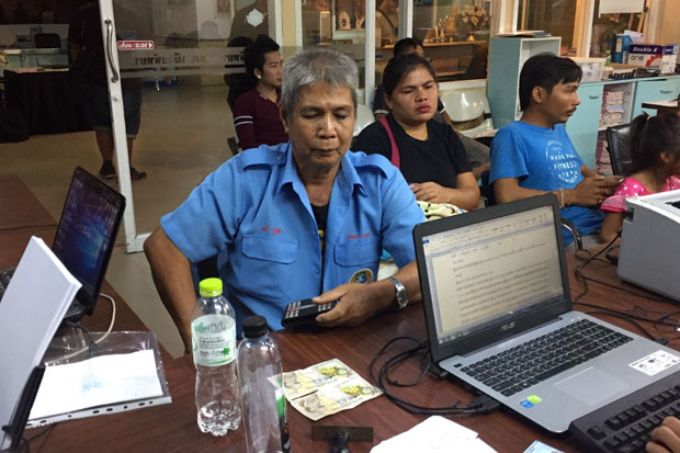 Songthaew bus driver Mani Phuchula shows Pattaya police the counterfeit banknotes his two passengers used to pay their fare on Sunday.(Photo by Chaiyot Pupattanapong)