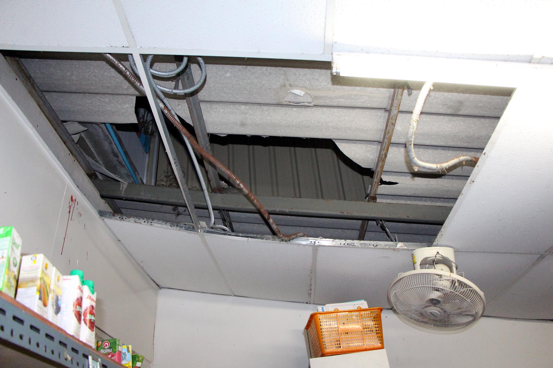 The roof of a 7-11 convenience store in Pattaya is damaged after a Russian woman fell through it on Sunday. (Photo by Chaiyot Pupattanapong)