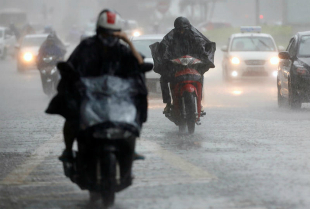 People travel in the rain caused by Talas typhoon on a street in Hanoi, Vietnam July 17, 2017. (Reuters photo)