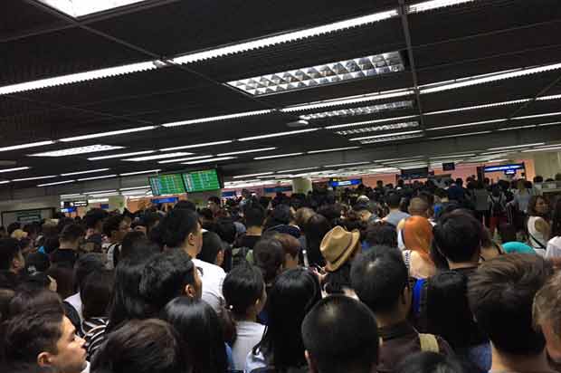 Foreign visitors queue for passport control at Don Mueang airport during a four-hour wait that stretched into Saturday morning. (Photo from the Facebook page of Piyabutr Saengkanokkul)