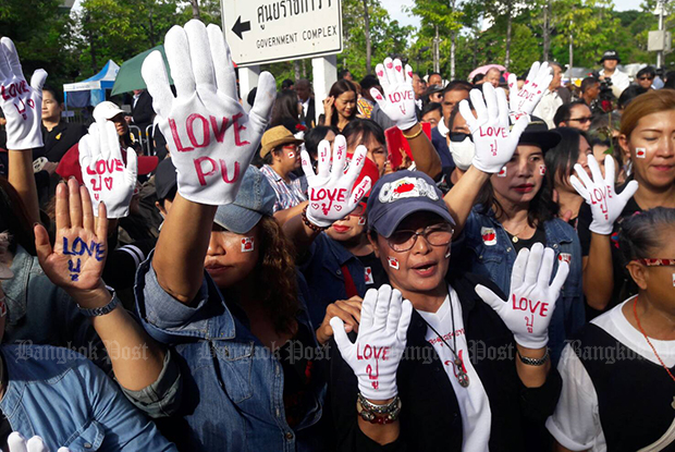 Supporters of former Prime Minister Yingluck Shinawatra wear white gloves with "love Puu" (her nickname) written on them. (Photo by Apichit Jinakul)