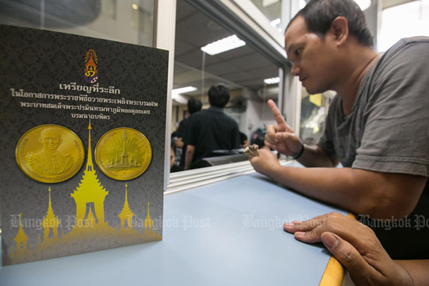 A man places an order for a commemorative cremation coin last Tuesday. (Bangkok Post file photo)