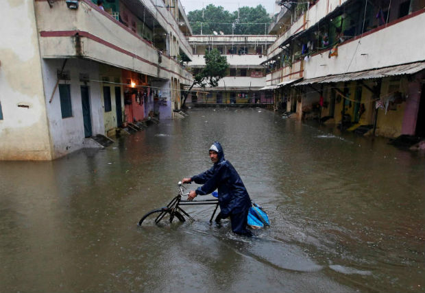 A delivery boy pushes his bicycle through a water-logged street after heavy rains at a residential colony in Mumbai, India Sept 20, 2017. (Reuters photo)