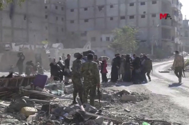 This frame grab from a video provided on Friday by Turkey-based Kurdish Mezopotamya agency media outlet shows US-backed Syrian Democratic Forces fighters standing around Syrian civilians who fled from the areas that still controlled by the Islamic State militants, in Raqqa, Syria. (AP photo) This frame grab from a video provided on Friday by Turkey-based Kurdish Mezopotamya agency media outlet shows US-backed Syrian Democratic Forces fighters standing around Syrian civilians who fled from the areas that still controlled by the Islamic State militants, in Raqqa, Syria. (AP photo)