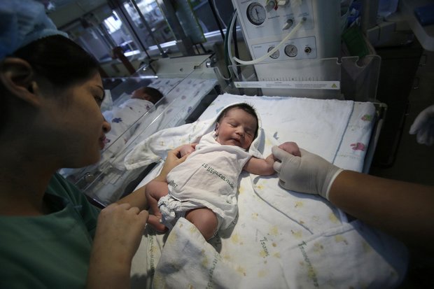 Nurses care for newborns at a Bangkok hospital. The Revenue Department will soon double the 30,000-baht tax deduction for infants and children, with a 60,000-baht deduction for the second and all subsequent child in a family. (AP file photo)