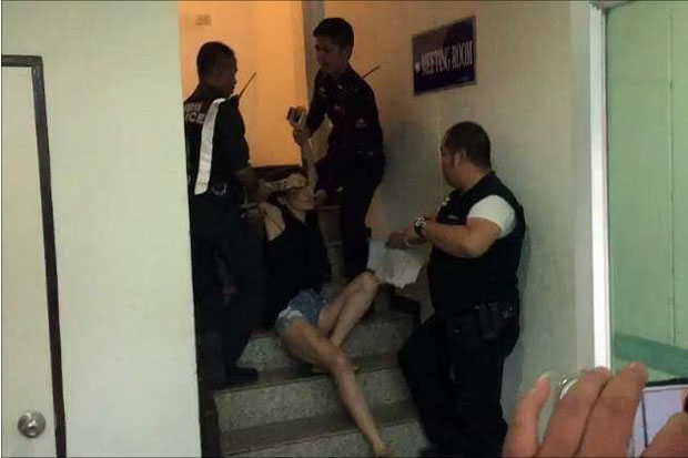 Police drag net idol Manussaya Yaowarat, aka Flukesri Maneedeng, up the stairs to a detention cell at Pattaya police station on Sunday. (Photo from the page of Facebook user Manussaya Yaowarat)