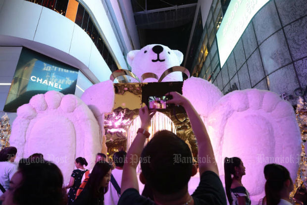 A man takes a picture of a giant polar bear display at the EmQuartier shopping mall packed with Christmas and New Year revellers in November 2017. (Photo by Patipat Janthong)