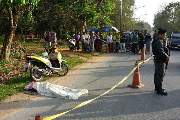 The body of Armeenoh Yuso, a Narathiwat resident, lies covered with a cloth while investigators inspect the scene of her murder in Rangae district, Narathiwat, on Friday morning. (Photo by Abdulloh Benjakat)