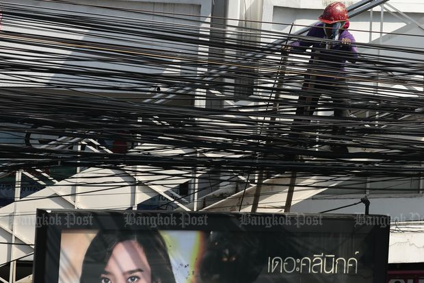 A worker installs internet cables at Suthisan intersection in Bangkok on Jan 18 this year. (Photo by Patipat Janthong)