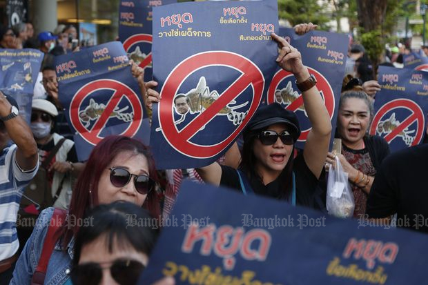 Pro-election demonstrators hold anti-junta signs near Democracy Monument on Ratchadamnoen Avenue on Saturday. The signs say: "Destroy dictatorship eggs", "Stop putting off the election" and "Stop power succession". (Photos by Pattarapong Chatpattarasill)