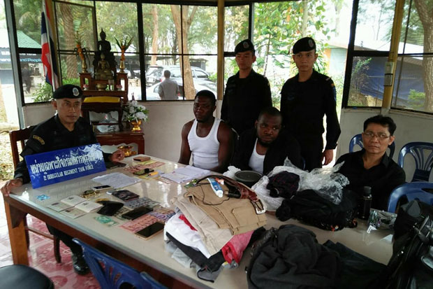 The two Nigerians are questioned by rangers of the Rong Kluea task force who caught them attempting to flee in a taxi after being spotted in the border market in Aranyaprathet district of Sakaeo province on Monday. They were charged with illegal entry.(Photo by Sawad Ketngam)