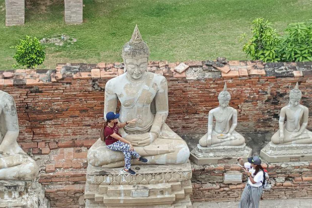 Woman sitting in lap of Buddha statue draws ire online