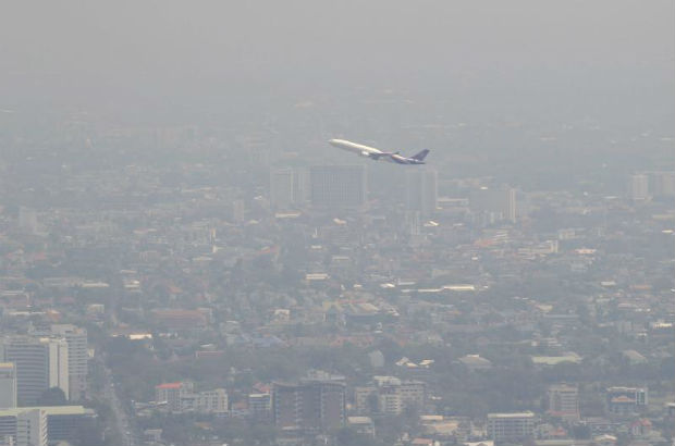 A Thai Airways International aircraft flies over Chiang Mai city, seen shrouded by smog in Chiang Mai province, northern Thailand, 04 March 2015.  (EPA file photo)