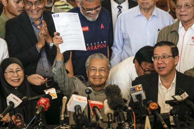 Mahathir Mohamad holds up the letter to the king that made him prime minister of Malaysia again. On the left is Azizah Wan Ismail, political ally and wife of jailed Anwar Ibrahim, who likely will be prime minister before the end of the year. (EPA photo)