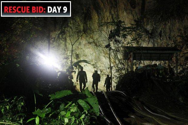 Rescue team members enter the Tham Luang cave on Sunday. The team got a break when the rains stopped and the pumps began making progress. (EPA photo)