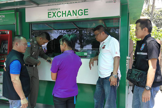 An 18-year-old hotel maid arrested for stealing money from a Russian tourist's room is taken to the currency booth where she exchanged the US banknotes for baht, during a re-enactment of the crime on Tuesday. (Photo: Pattaya tourist police)