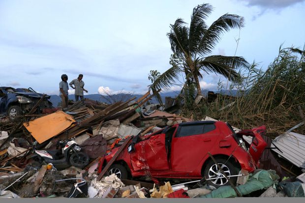 Men chat on top of the rubble at Petobo neighborhood, which was wiped out by the earthquake-triggered tsunami, in Palu, Central Sulawesi, Indonesia, on Sunday. (AP Photo) Men chat on top of the rubble at Petobo neighborhood, which was wiped out by the earthquake-triggered tsunami, in Palu, Central Sulawesi, Indonesia, on Sunday. (AP Photo)