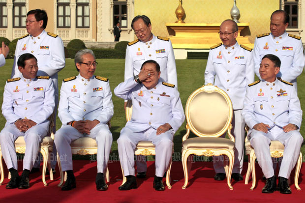 Cabinet members enjoy a humorous moment as Deputy Prime Minister and Defence Minister Prawit Wongsuwon raises his hand to cover his eyes amid strong sunlight after journalists teased him about his flashy watch and diamond ring as they waited for Prime Minister Prayut Chan-ocha to join them for a group photo at Government House in December 2017. (Photo by Chanat Katanyu)