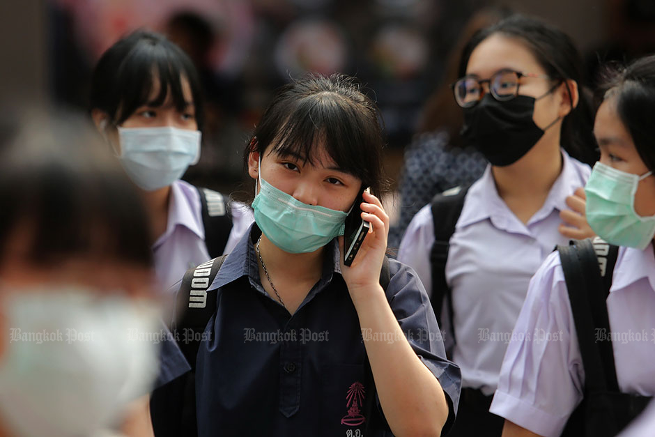 Students protect themselves with face masks in the Siam Square area of Bangkok. — Wichan Charoenkiatpakul