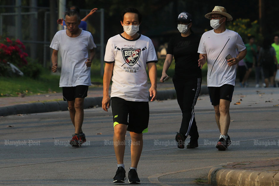 City residents don face masks while performing their daily exercises. — Patipat Janthong