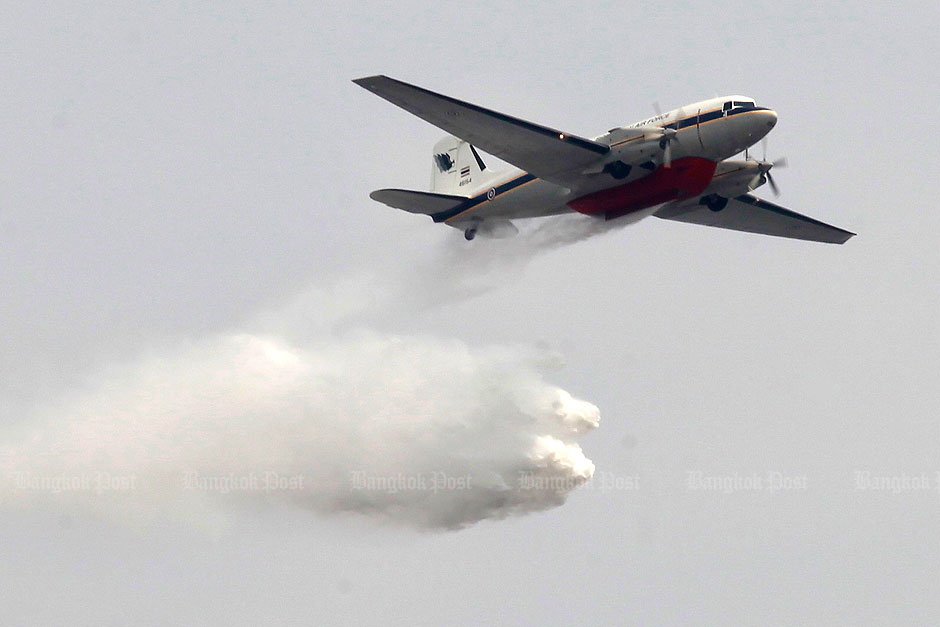 A Royal Thai Air Force Basler BT-67 firefighting plane showers water above Bangkok's Don Muang district. — Pornprom Satrabhaya
