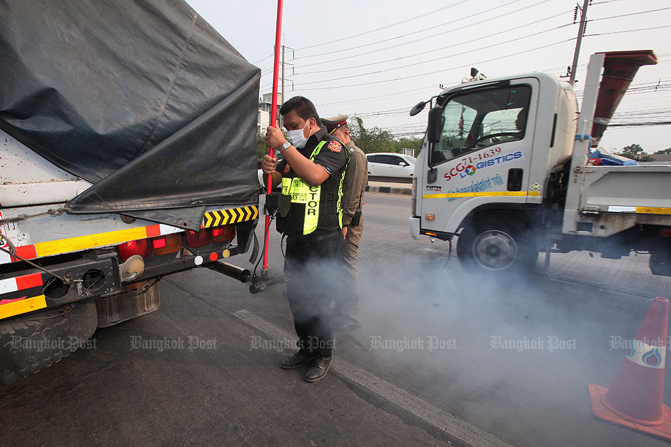Police and land transport officers inspect exhaust fumes from a lorry in Pathum Thani's Klong Luang district in an information gathering programme to combat air pollution. — Apichit Jinakul