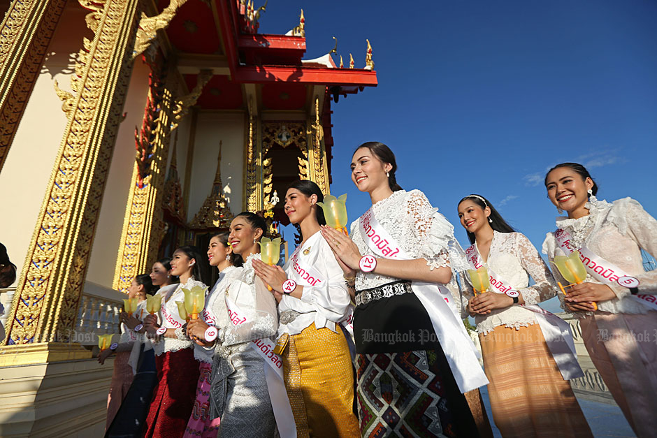 Dressed in Thai traditional outfits, Miss Thailand World 2019 contestants hold a candle while doing a 'wian thian' walk at a Buddhist temple in Saraburi on Asarnha Bucha Day yesterday. The religious activity was part of the beauty contest programme. (Photo by Varuth Hirunyatheb)