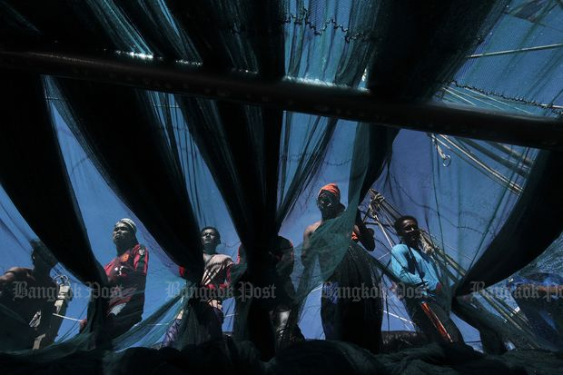 Migrant workers sort out fishing nets on a boat in Phangnga in 2014. (Bangkok Post file photo)