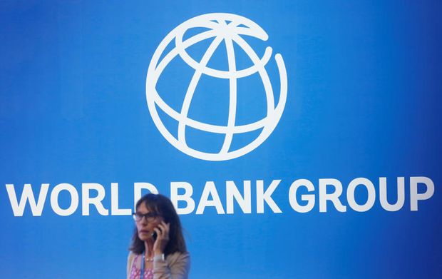 A participant stands near a logo of the World Bank at the International Monetary Fund - World Bank Annual Meeting 2018 in Nusa Dua, Bali, Indonesia, Oct 12, 2018. (Reuters photo)