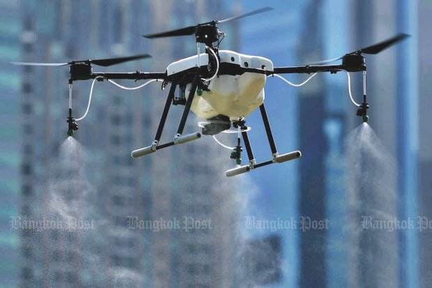 A drone produces water and non-hazardous chemical spray to diffuse the dust particles at Vachirabenjatas Park, also known as Rot Fai Park, in Chatuchak district during a test run on Tuesday. (Photo by Patipat Janthong)