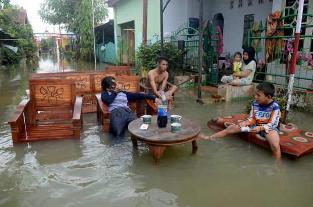 Residents sit as they clean up their property following floods at a residents area in Makassar, South Sulawesi, Indonesia, on Friday. (Antara Foto) Residents sit as they clean up their property following floods at a residents area in Makassar, South Sulawesi, Indonesia, on Friday. (Antara Foto)