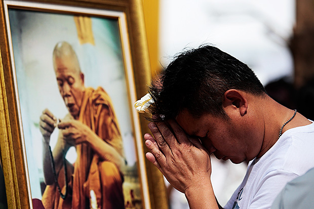 A follower pays his respects before a picture of Luang Phor Koon Parisutho as final preparations were underway for the royally-sponsored funeral on Tuesday.